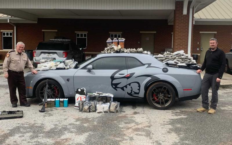 Hart County Sheriff Mike Cleveland (left) and Capt. Chris Carroll stand with the seized "Jail Break Hell Cat" Dodge Challenger, drugs and weapons.