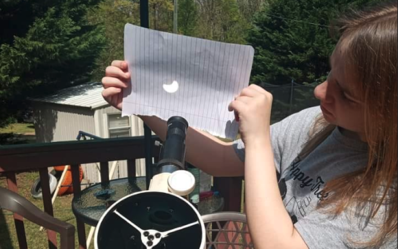 Hartwell native Josie Carter uses her Explore First light 114mm Newtonian Reflector Telescope with Twilight Nano to show where the moon is covering the sun. 