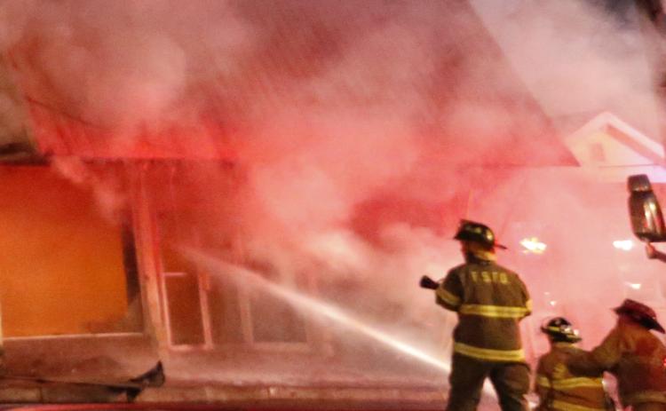 Firefighters work to extinguish a fire Tuesday in the former Royce Theatre building in downtown Royston. The building was being used for storage at the time of the fire, which was contained to just that building. 