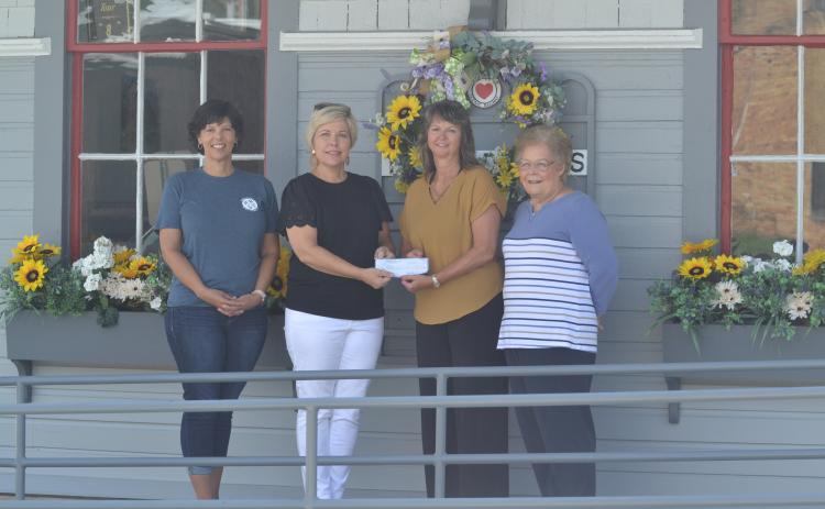 Hart EMC public relations director Angie Brown (center-left) presents a $3,000 check at the Railroad Street train depot to TORCH board members Sharon Morris (left), Kristin Joyner (center right) and TORCH president Mary Gidley (right).