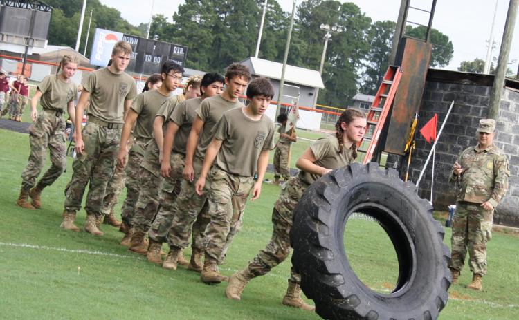 The Hart County JROTC competes in the tire flip.