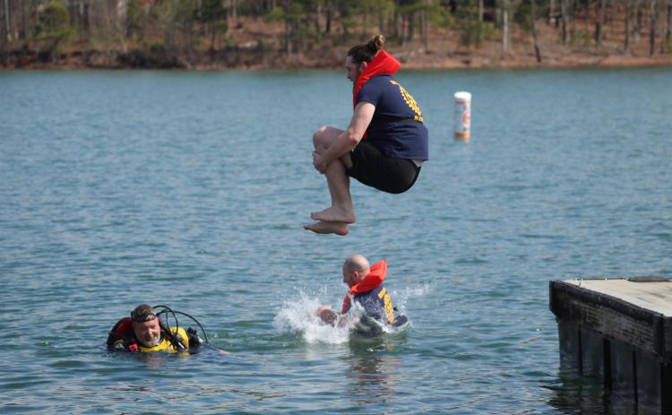 Grayson Williams makes a cannonball during the 28th Polar Plunge March  2 at Lake Hartwell. Williams and Mike Baier represented the Hartwell Rotary club while Hart County EMT Jason Hailey looks on. Photo by Holly and Honeysuckle Co.